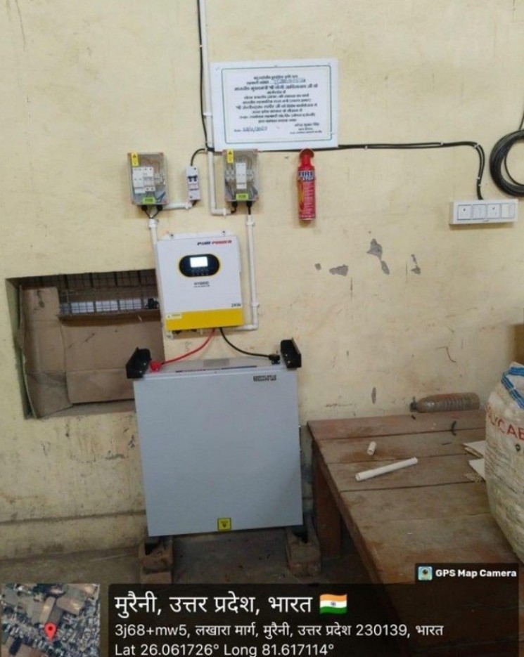 Commissioning photograph of a wall-mounted inverter and battery enclosure in Muraini, Pratapgarh District